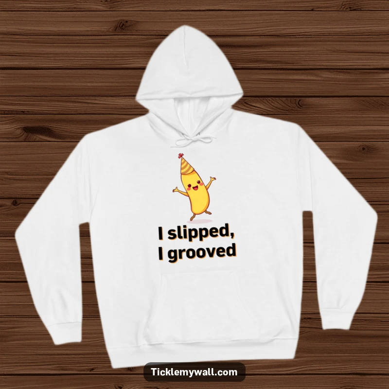 Funny dancing banana wearing a party hat slipping on its own peel on a warm fleece hoodie.