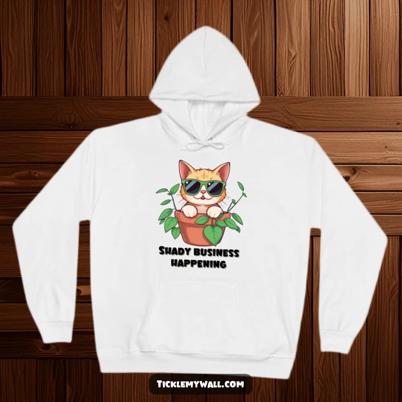 Funny surprised cat wearing oversized sunglasses peeking from a potted plant, featured on a soft hoodie for cozy, humorous wear.