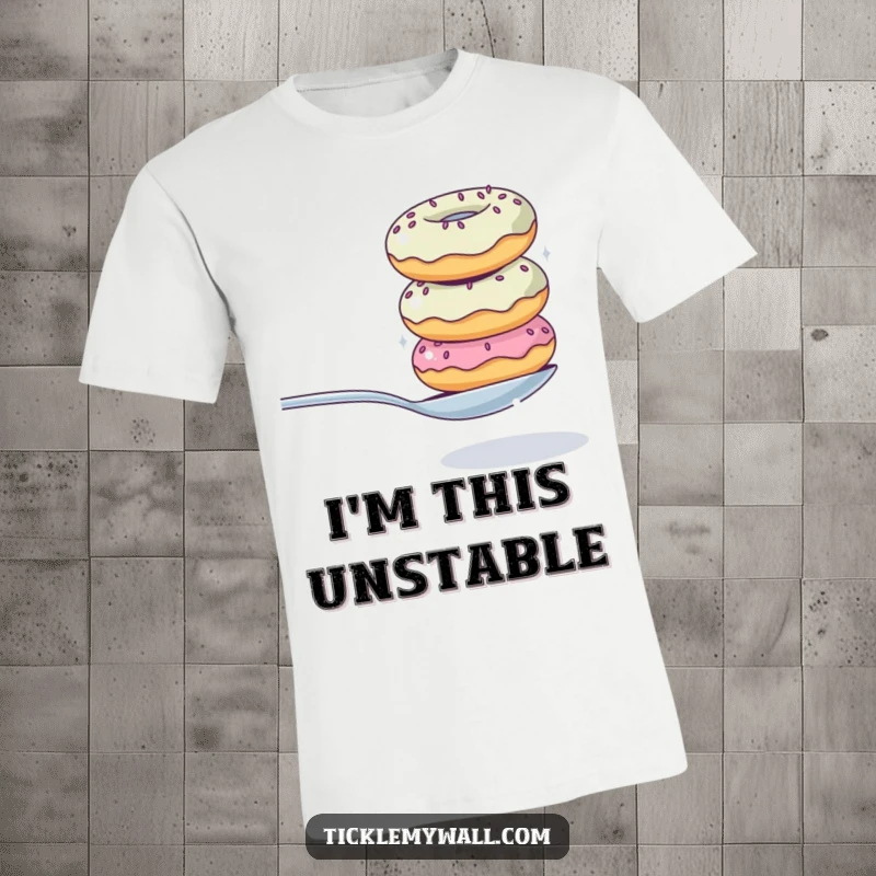 Funny t-shirt featuring a wobbly tower of donuts hilariously attempting to balance a spoon, capturing a sweet and unstable moment.